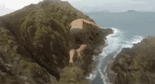 A Man Without A Shirt Is Jumping Into The Ocean GIF