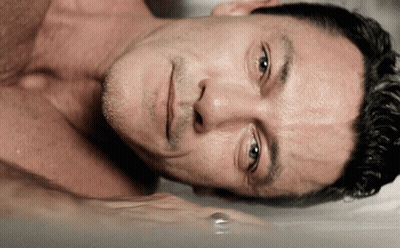 A Man Without A Shirt Is Laying In A Bathtub With His Eyes Closed GIF