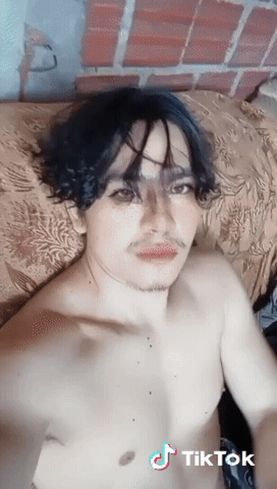 A Man Without A Shirt Is Laying On A Bed With A Tiktok Watermark GIF