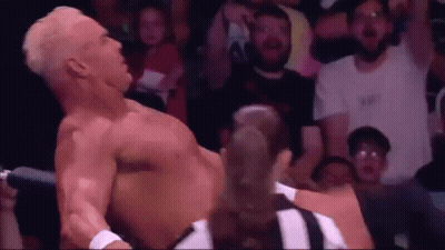 A Man Without A Shirt Is Laying On The Ground In Front Of A Crowd . GIF