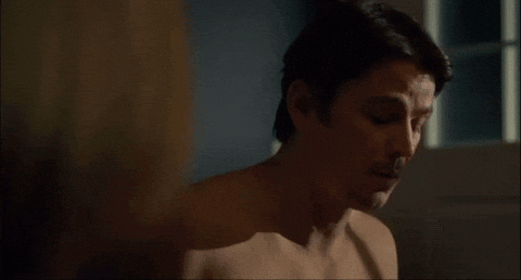 A Man Without A Shirt Is Looking At A Woman 'S Breast . GIF