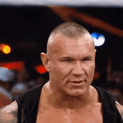 A Man Without A Shirt Is Looking At The Camera With A Serious Look On His Face GIF
