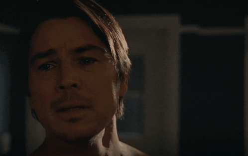 A Man Without A Shirt Is Looking At The Camera With A Serious Look On His Face GIF
