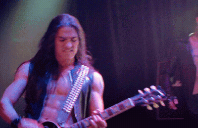 A Man Without A Shirt Is Playing A Guitar GIF
