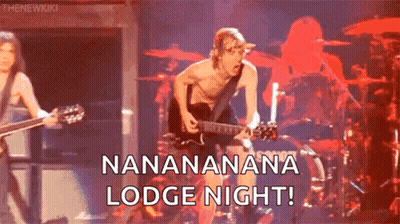A Man Without A Shirt Is Playing A Guitar On A Stage In Front Of A Drummer . GIF