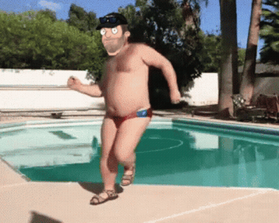 A Man Without A Shirt Is Running By A Pool Wearing Red Swim Trunks GIF