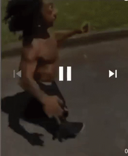 A Man Without A Shirt Is Running Down The Street GIF