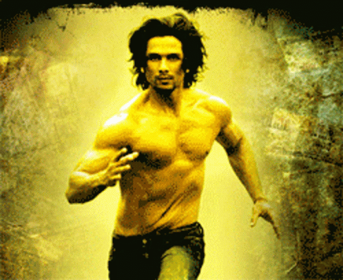 A Man Without A Shirt Is Running In A Dark Room GIF