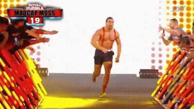 A Man Without A Shirt Is Running In Front Of A Crowd Of People . GIF