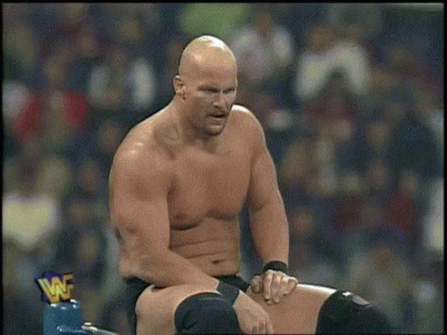 A Man Without A Shirt Is Sitting On A Ring With A Wwe Logo On It . GIF
