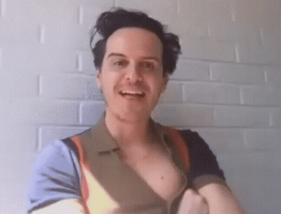 A Man Without A Shirt Is Smiling In Front Of A White Wall GIF