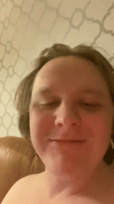 A Man Without A Shirt Is Smiling With His Eyes Closed . GIF