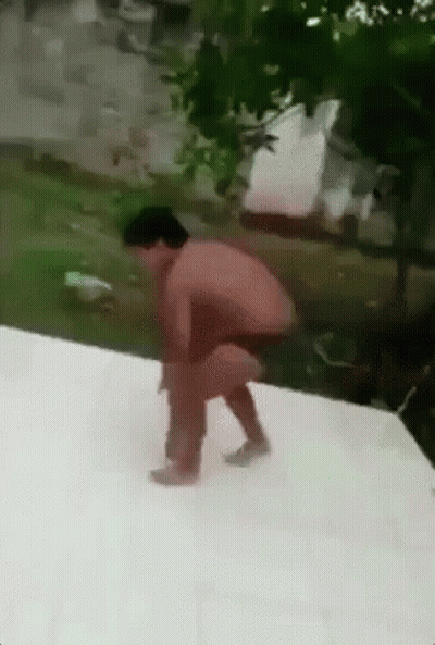 A Man Without A Shirt Is Squatting Down On A White Surface . GIF
