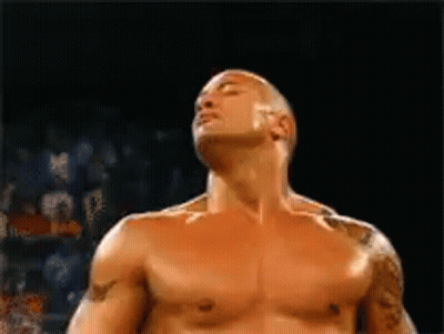 A Man Without A Shirt Is Standing In A Boxing Ring With His Eyes Closed . GIF