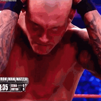 A Man Without A Shirt Is Standing In A Boxing Ring With His Hands Behind His Head . GIF