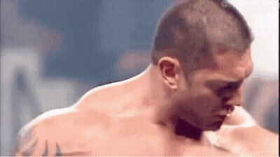 a man without a shirt is standing in a boxing ring .
