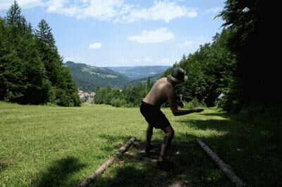 A Man Without A Shirt Is Standing In A Grassy Field GIF