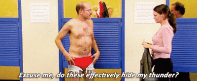 A Man Without A Shirt Is Standing In A Locker Room With A Woman . GIF
