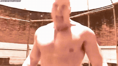 A Man Without A Shirt Is Standing In A Ring With His Mouth Open . GIF