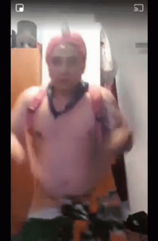 A Man Without A Shirt Is Standing In A Room Wearing A Pink Hat And Sunglasses GIF