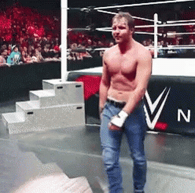 A Man Without A Shirt Is Standing In A Wrestling Ring In Front Of A Banner That Says N On It GIF