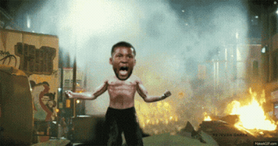 A Man Without A Shirt Is Standing In Front Of A Burning Building GIF