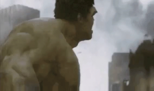 A Man Without A Shirt Is Standing In Front Of A City With Buildings In The Background . GIF