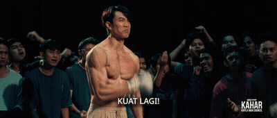 A Man Without A Shirt Is Standing In Front Of A Crowd And The Caption Kuat Lagi GIF