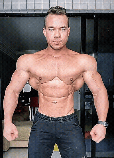 A Man Without A Shirt Is Standing In Front Of A Door With His Hands On His Hips GIF