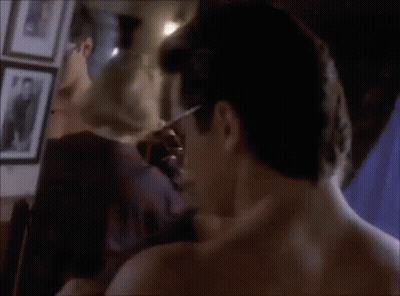 A Man Without A Shirt Is Standing In Front Of A Mirror Looking At His Reflection GIF