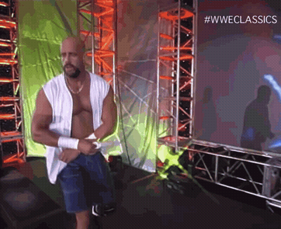 A Man Without A Shirt Is Standing In Front Of A Screen That Says #Wweclassics . GIF