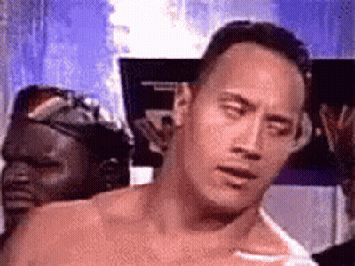 A Man Without A Shirt Is Standing In Front Of A Sign And Making A Funny Face . GIF