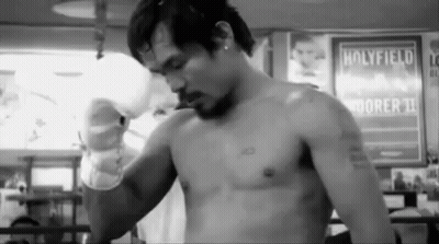 A Man Without A Shirt Is Standing In Front Of A Sign That Says Holyfield On It . GIF