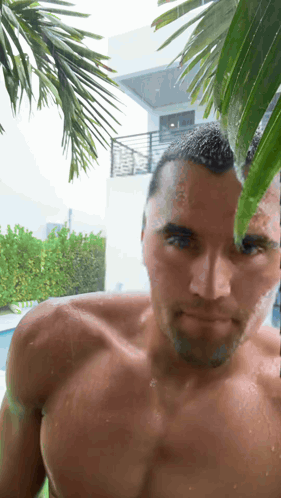 A Man Without A Shirt Is Standing In The Rain GIF