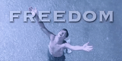 A Man Without A Shirt Is Standing In The Rain With His Arms Outstretched In Front Of The Word Freedom . GIF
