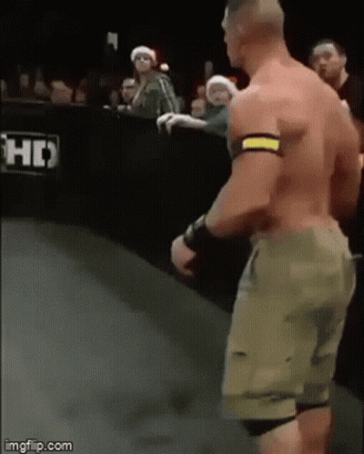 A Man Without A Shirt Is Standing On A Wrestling Ring . GIF