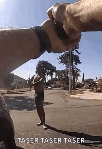 A Man Without A Shirt Is Standing On The Side Of The Road Being Held By Another Man 'S Hand . GIF