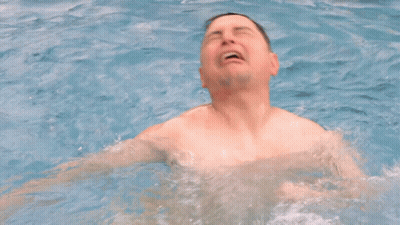 A Man Without A Shirt Is Swimming In A Pool With His Mouth Open GIF