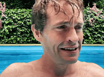 A Man Without A Shirt Is Swimming In A Pool With His Mouth Open GIF
