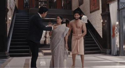 A Man Without A Shirt Is Talking To A Woman And A Man In A Towel GIF