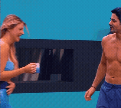 A Man Without A Shirt Is Talking To A Woman In A Mermaid Costume GIF