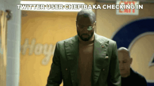 A Man Without A Shirt Is Walking Down A Hallway With The Words Twitter User Chefbaka Checking In Above Him GIF