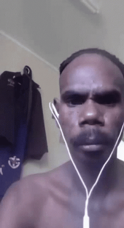 A Man Without A Shirt Is Wearing Earbuds And Looking At The Camera GIF