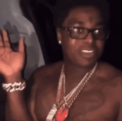 A Man Without A Shirt Is Wearing Glasses And A Chain GIF