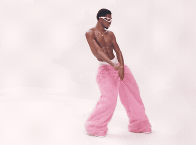 A Man Without A Shirt Is Wearing Pink Pants And Sunglasses GIF