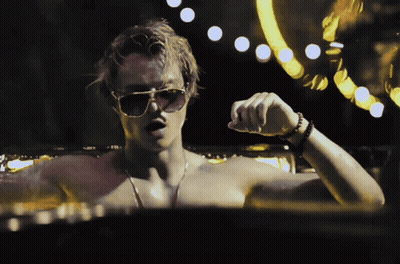 A Man Without A Shirt Is Wearing Sunglasses And A Watch GIF