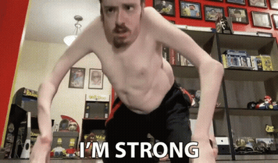A Man Without A Shirt Says I 'M Strong In A Room Full Of Toys GIF