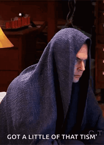 A Man Wrapped In A Blanket With The Words Got A Little Of That Tism 'T Written Below Him GIF