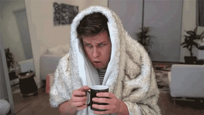 A Man Wrapped In A Furry Blanket Holds A Cup Of Coffee GIF