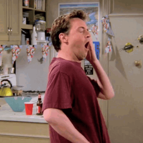 A Man Yawning In A Kitchen With A Bottle Of Beer GIF